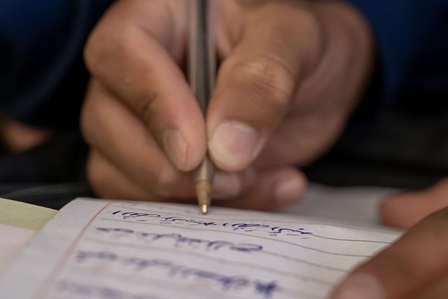 A close-up of a student writing in a notebook