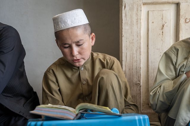 A student reading a book at his desk