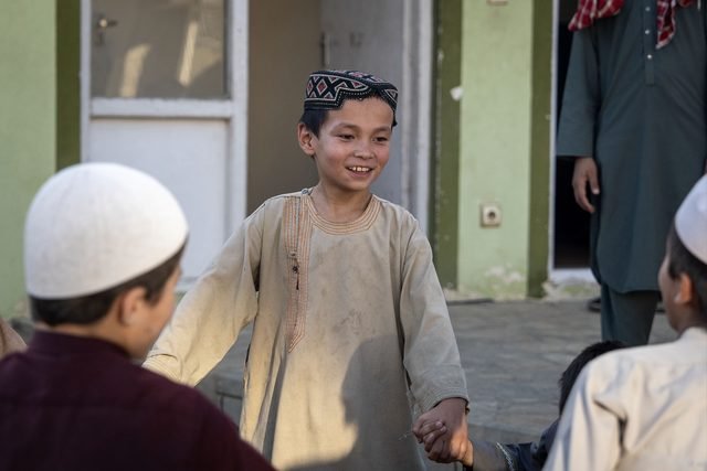 A smiling child spending time with other children in the courtyard