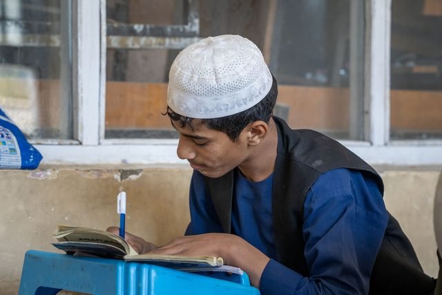 A student writing at his desk